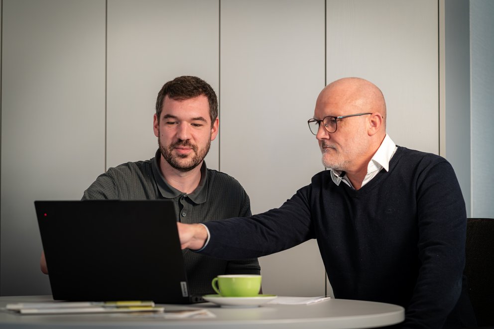 Zwei Personen schauen auf einen Bildschirm Zwei Personen schauen auf einen Bildschirm