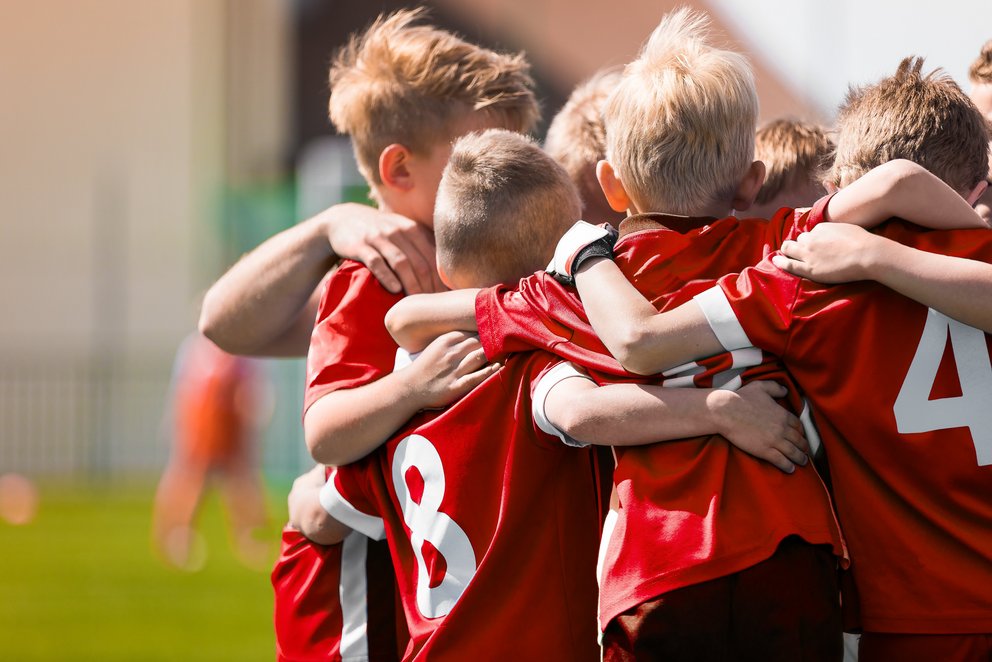 Kinder einer Mannschaft, die sich gegenseitig umarmen. Kinder einer Mannschaft, die sich gegenseitig umarmen.