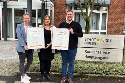 Die Mitarbeiter präsentieren stolz die Urkunden für das TOP-Lokalversorger-Siegel.