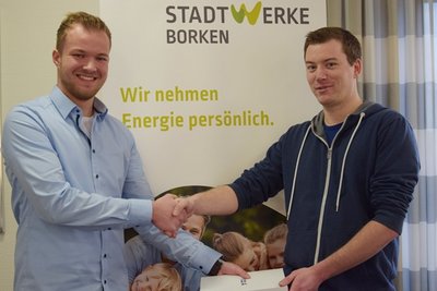 Marin Vilain übergibt händeschüttelnd ein Tablet an Jägering