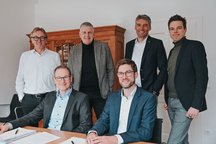  Gruppe von sechs Personen, die in einem Büro stehen