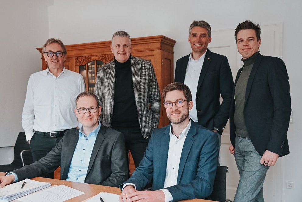 Gruppe von sechs Personen Gruppe von sechs Personen, die in einem Büro stehen