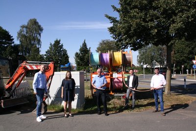 4 Personen vor Anhänger mit Leerrohr-Trommeln