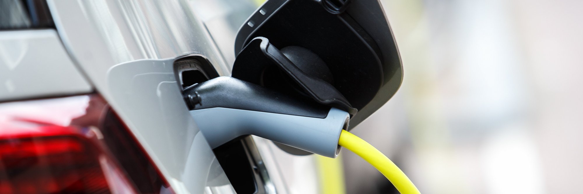 Elektrofahrzeug an Ladesäule angeschlossen ein Elektroauto, das an einer Ladestation angeschlossen ist, um aufgeladen zu werden.