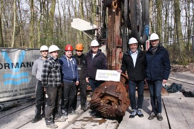 Gruppenfoto Arbeiter der Bohrfirma und Mitarbeiter der Stadtwerke vor Bohrgerät 