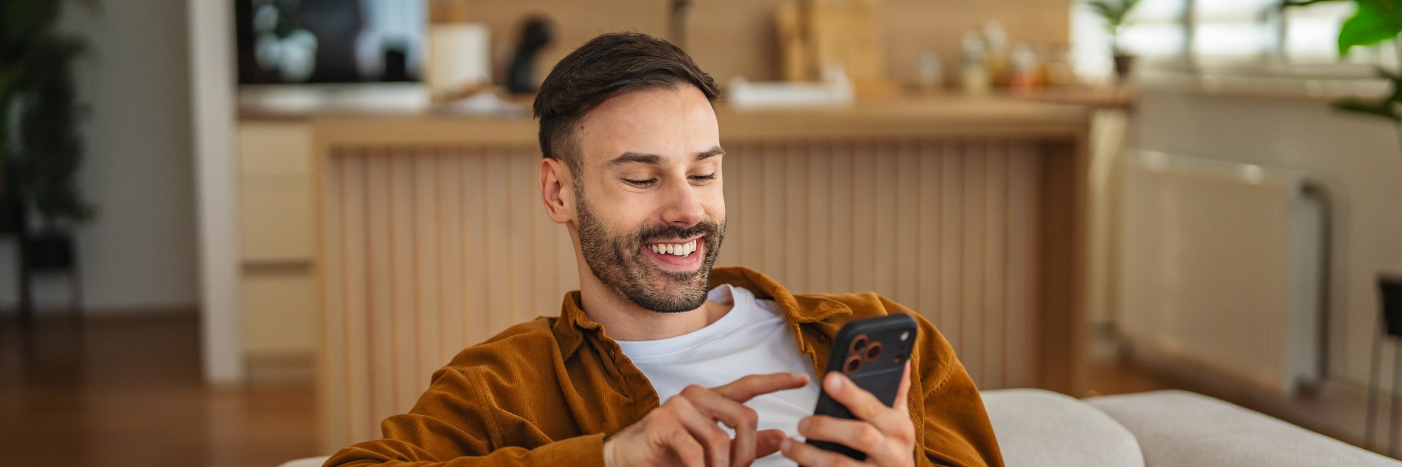 Mann mit Handy in der Hand lächelnd. Mann mit Handy in der Hand lächelnd.