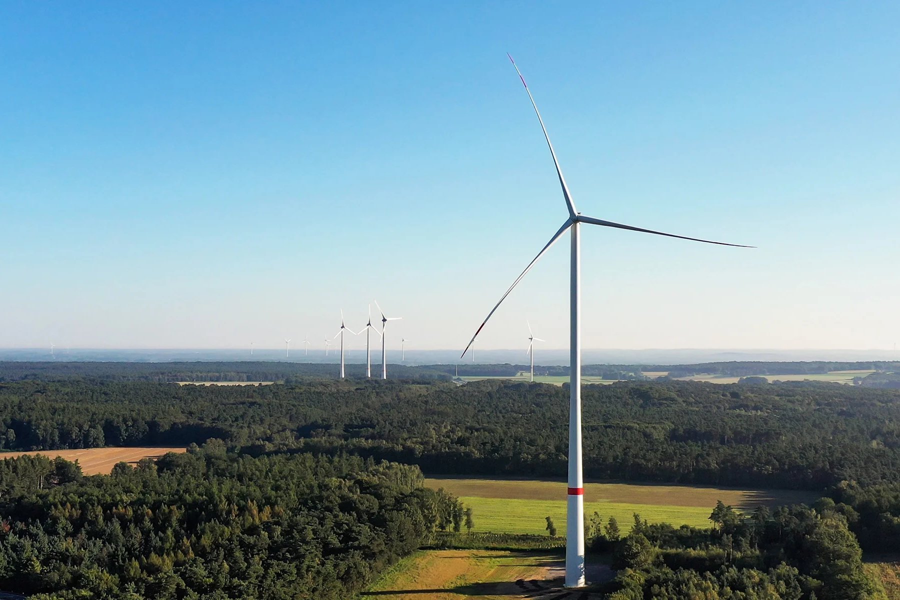 Windturbine in grüner Landschaft Das Bild zeigt eine Windturbine, die in einer weiten, grünen Landschaft steht.