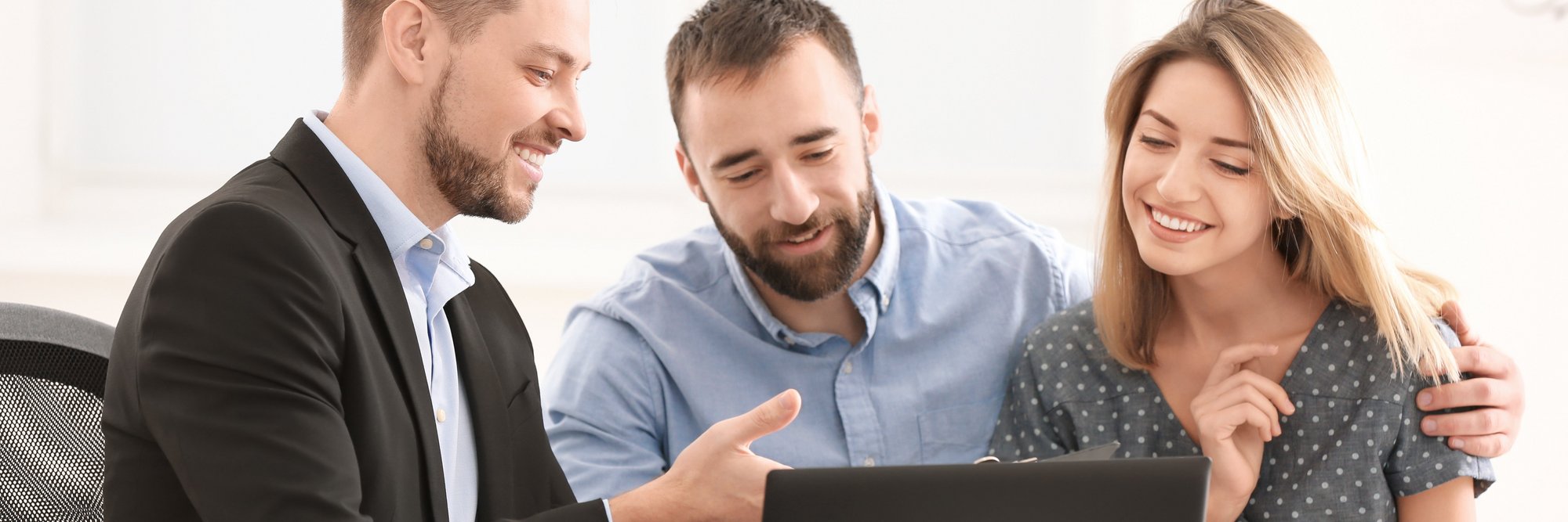 Drei Personen arbeiten gemeinsam am Laptop. Drei Personen arbeiten gemeinsam an einem Laptop und unterhalten sich dabei. Sie wirken freundlich und kooperativ.