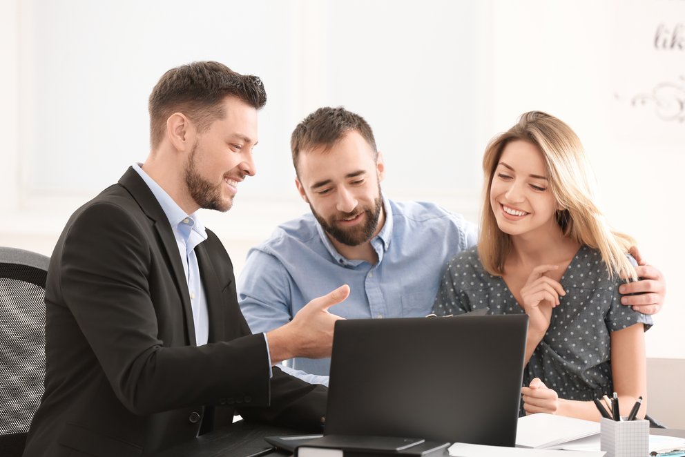 Drei Personen arbeiten gemeinsam am Laptop. Drei Personen arbeiten gemeinsam an einem Laptop und unterhalten sich dabei. Sie wirken freundlich und kooperativ.