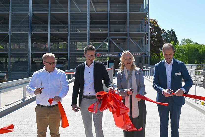 4 Personen schneiden Schleifenband durch