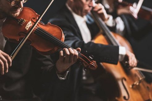 Auf dem Bild sieht man ein Musikorchester. Verschiedene Musikinstrumente wie z.B. eine Geige werden gespielt.