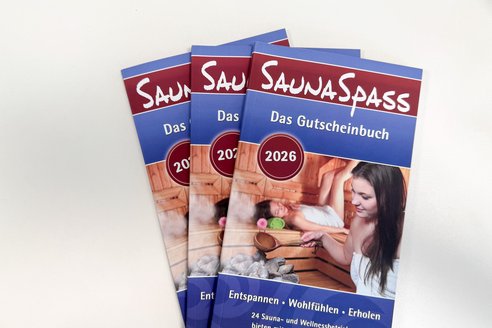 Auf dem Bild sieht man mehrere Gutscheinbücher. Es geht um das Thema Sauna und Wellness.
