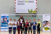 Jungen mit Pokalen und Annette Dirks vor Stadtwerke Banner