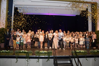 Teilnehmer auf der Bühne im Goldregen