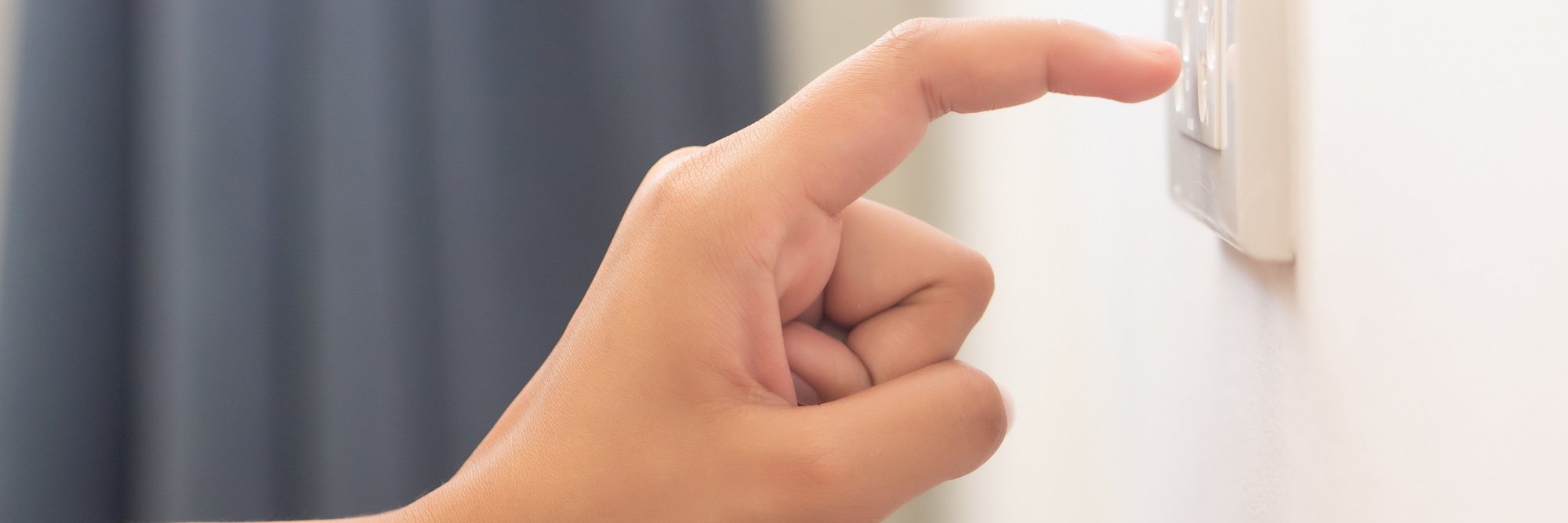 Hand zeigt auf Steckdose. Ein Finger, der auf eine Steckdose zeigt.