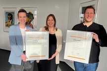 Die Mitarbeiter präsentieren die neuen Urkunden des Top-Lokalversorger Siegels.